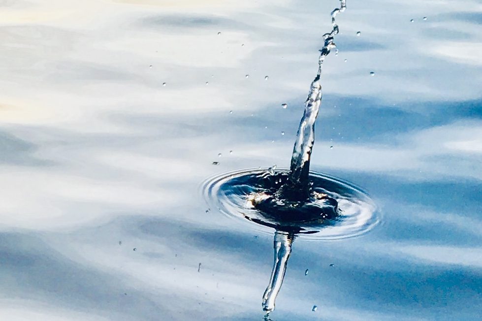 Kinesionlogisches Coaching wie ein Wassertropfen auf eine ruhige Wasseroberfläche Wassertropfen, der auf die Oberfläche eines ruhigen Gewässers trifft und Wellen erzeugt.